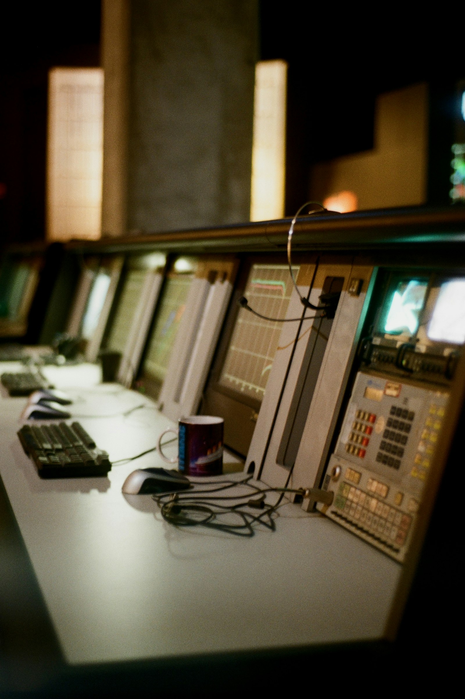 Broadcast control room wall of glowing monitors in a dark studio, where the broadcast license tier applies